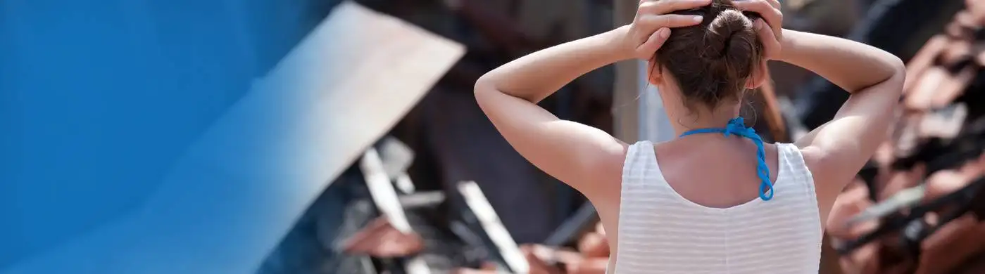 Person adjusting their hair outdoors with blurred background.